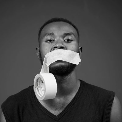 A man with a roll of tape hanging from his mouth